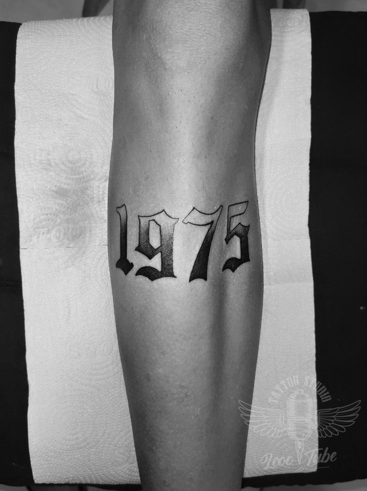 a person with a tattoo on their leg that reads 1971 and has the number seventy seven