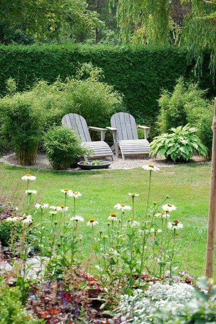 two lawn chairs sitting on top of a lush green field