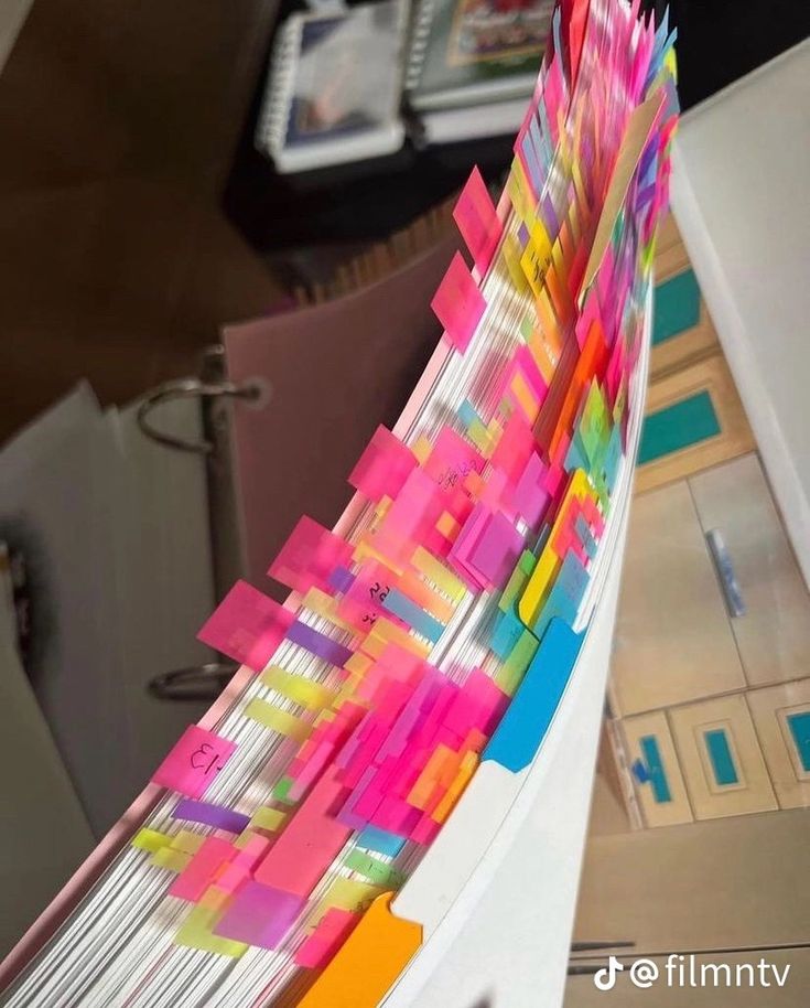 a stack of colorful papers sitting on top of a desk