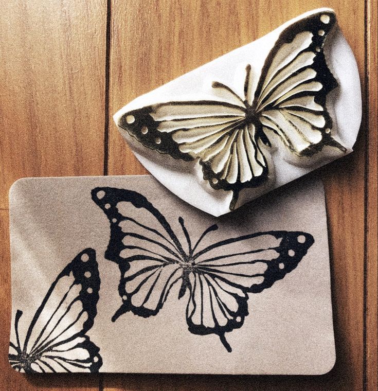 two butterflies are sitting on top of a placemat, one is white and the other is black