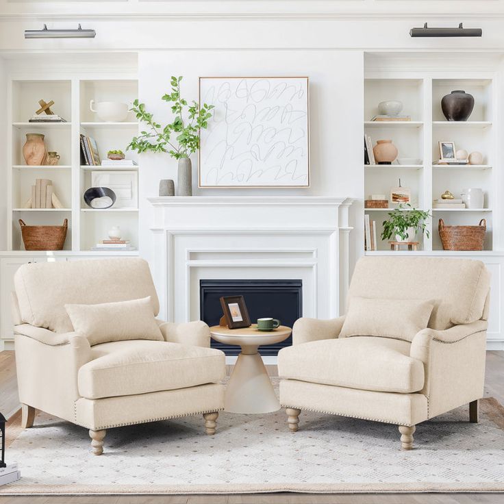 a living room with two chairs and a fire place