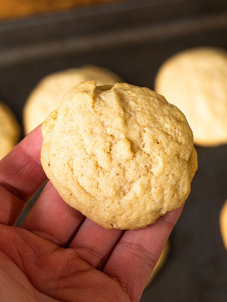 a hand holding a cookie in front of some cookies