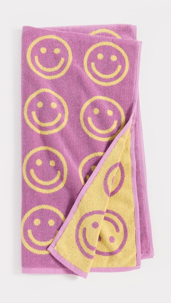 two towels with smiley faces on them, one is pink and the other is yellow