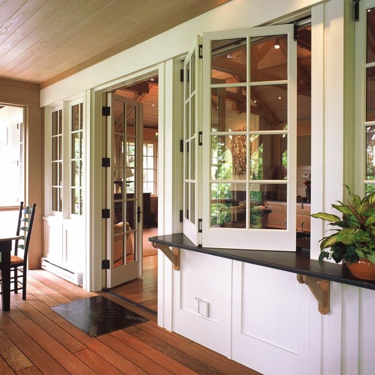 a dining room and kitchen area with wooden floors