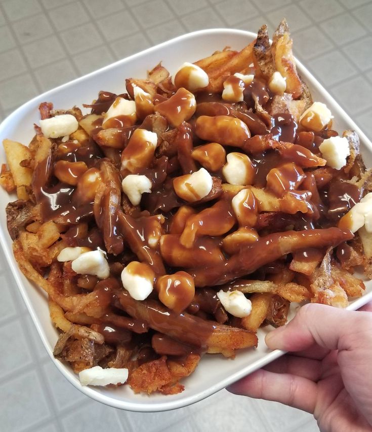 a white plate topped with lots of food on top of a tiled floor covered in sauce