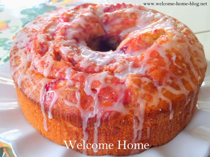 a bundt cake sitting on top of a white plate covered in icing and drizzle