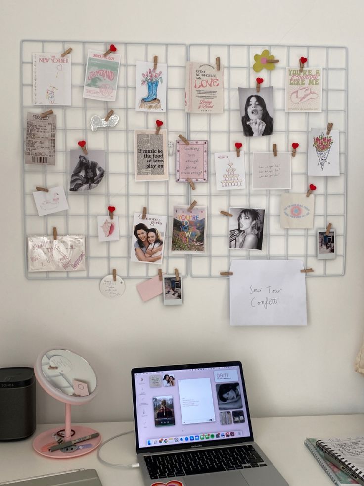 a laptop computer sitting on top of a desk next to a wall with pictures and magnets