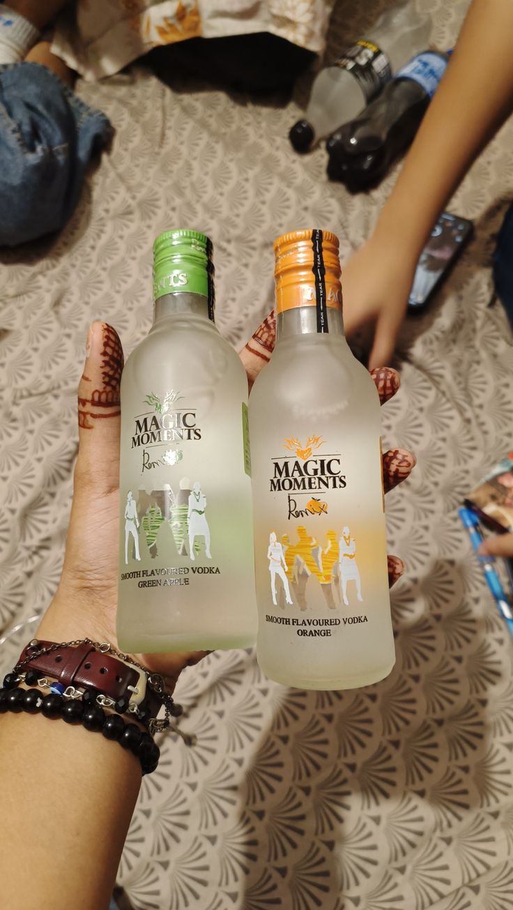 two bottles of magic's lemonade are being held by someone on the bed