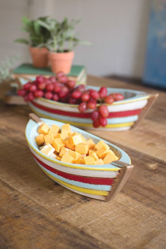 two bowls filled with fruit sitting on top of a wooden table