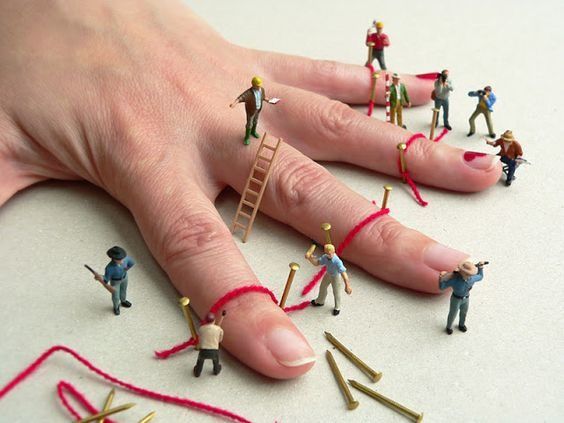 miniature people are standing on the table with their fingers in the air and one person is holding a ladder