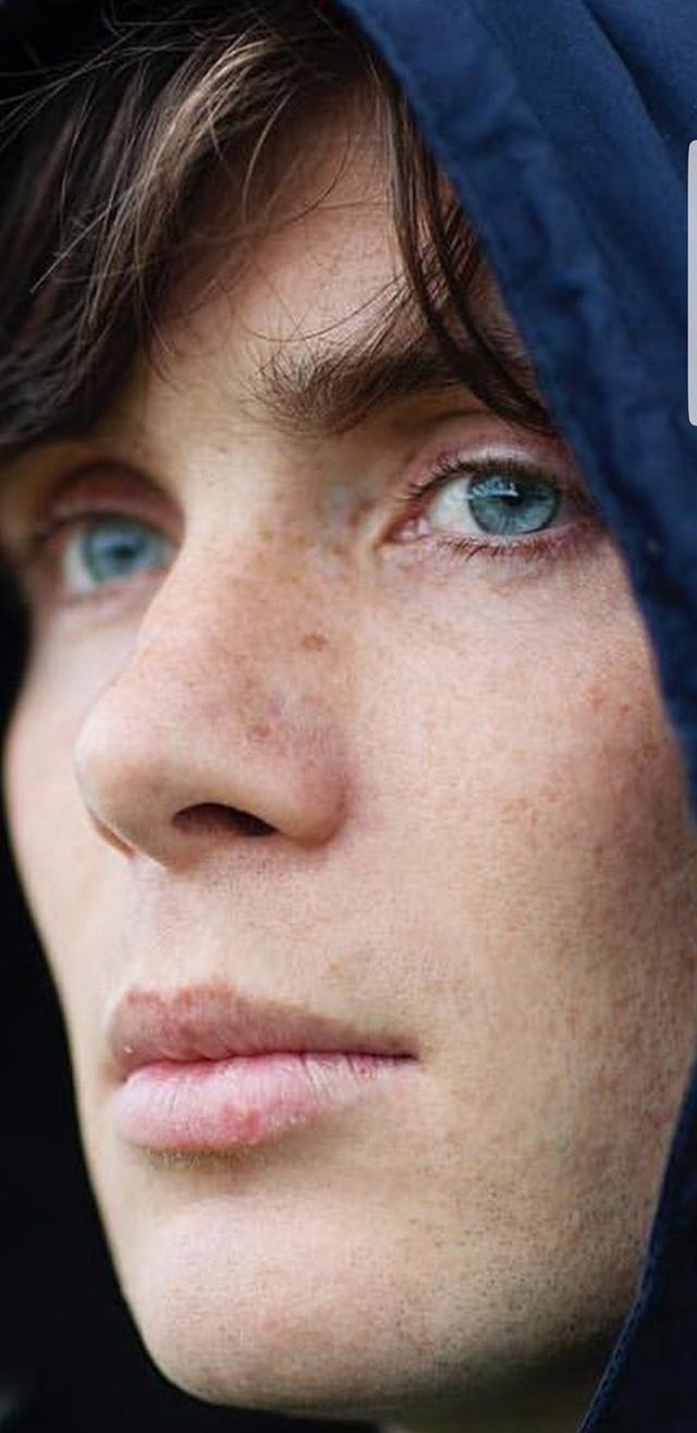 a close up of a person wearing a hoodie and looking off into the distance