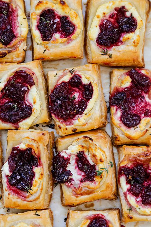 many small pastries with cranberry sauce on them