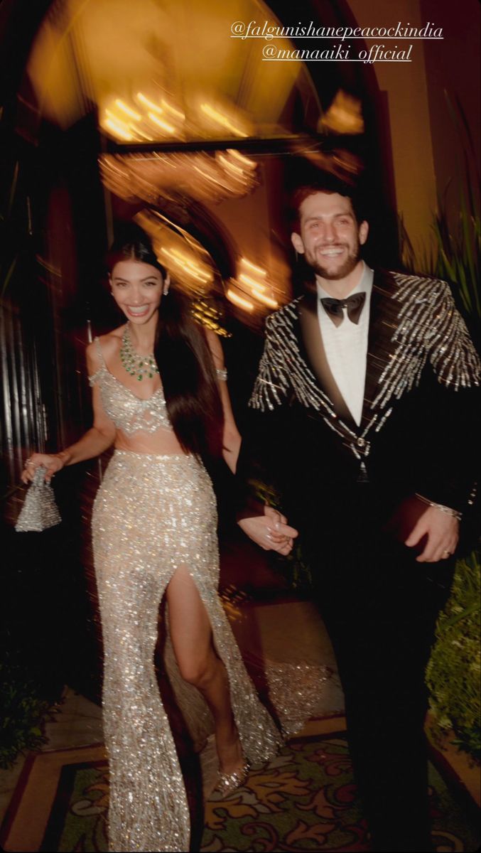 a man in a tuxedo standing next to a woman wearing a sequin skirt