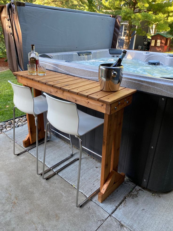 an outdoor hot tub table with chairs around it