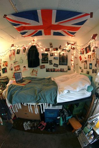 a bedroom with an union jack flag hanging from the ceiling and pictures on the wall