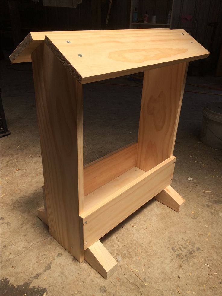 an unfinished wooden shelf sitting on the ground