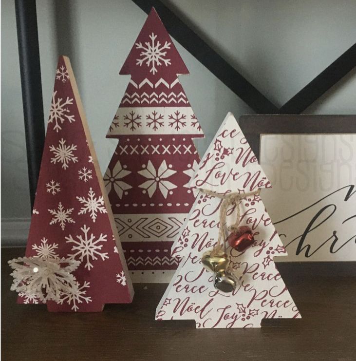 three wooden christmas trees sitting on top of a table next to a framed sign with the words upcycle christmas tree decor - quick & easy and easy