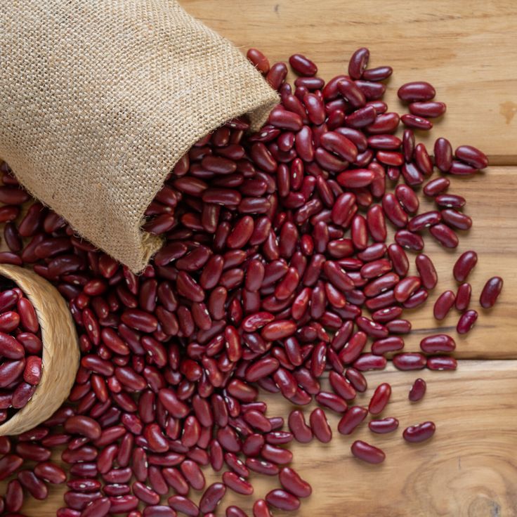 red beans spilling out of a sack onto a wooden table