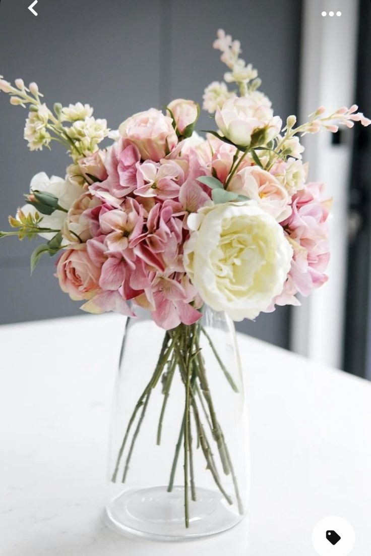 a vase filled with lots of pink and white flowers