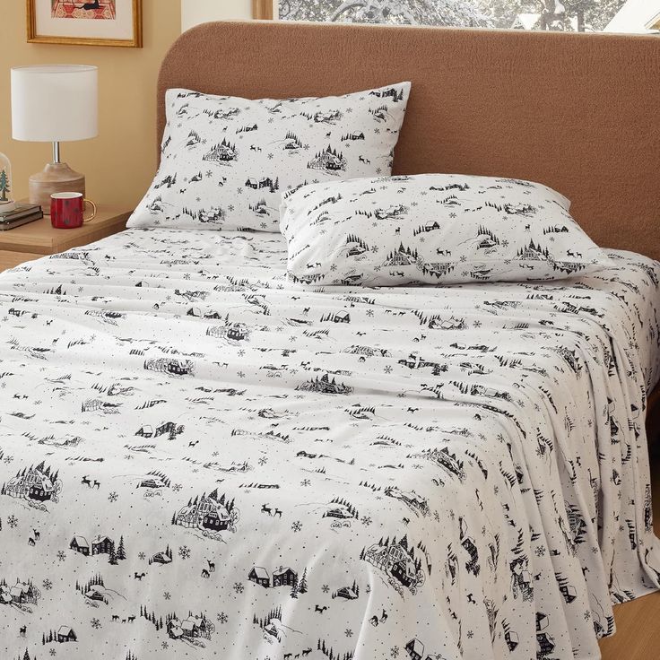 a bed with white sheets and black animals on it