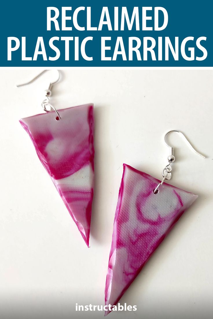 two pink and white triangle shaped earrings with the words reclamed plastic earrings on them