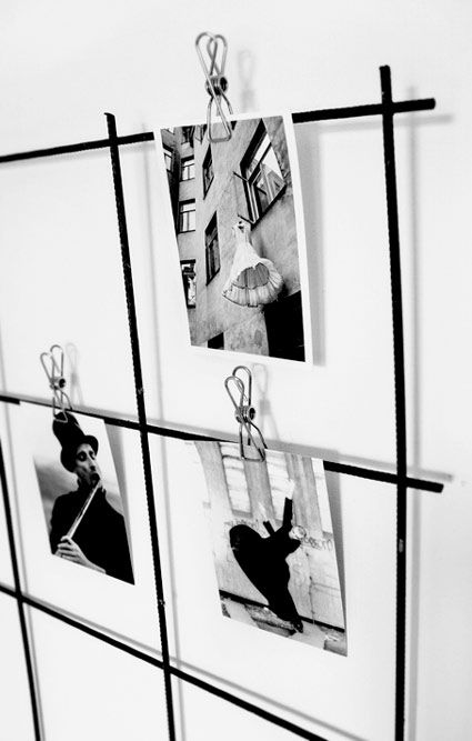 black and white photographs hanging on a wall with metal bars attached to the side of it