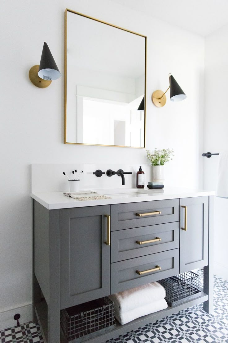 a bathroom with a sink, mirror and black and white tile flooring in it