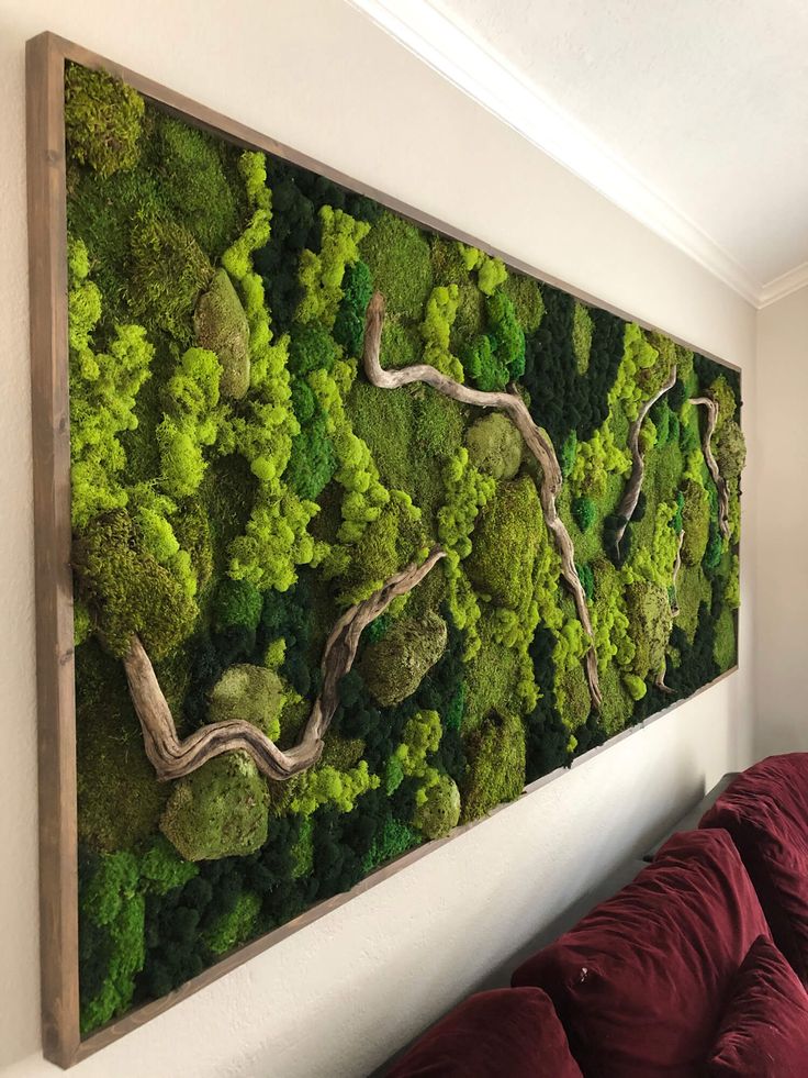 a living room with a moss wall hanging on the wall