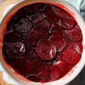 a large pot filled with beets on top of a wooden table