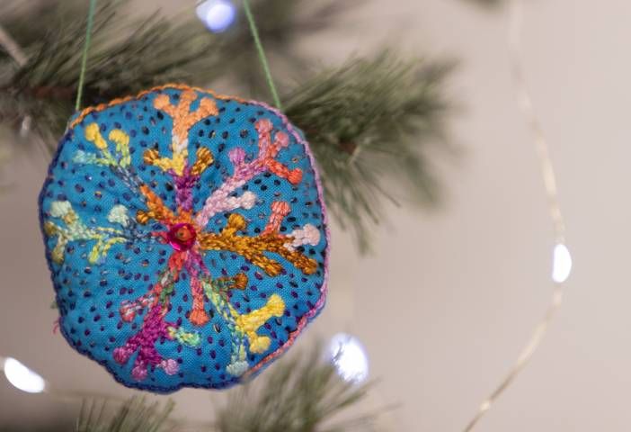 a blue ornament hanging from a christmas tree