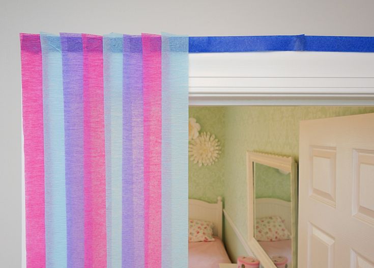 there is a pink and blue striped curtain in the room next to a door that has a mirror on it