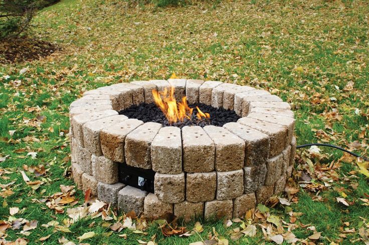 a fire pit made out of bricks in the grass