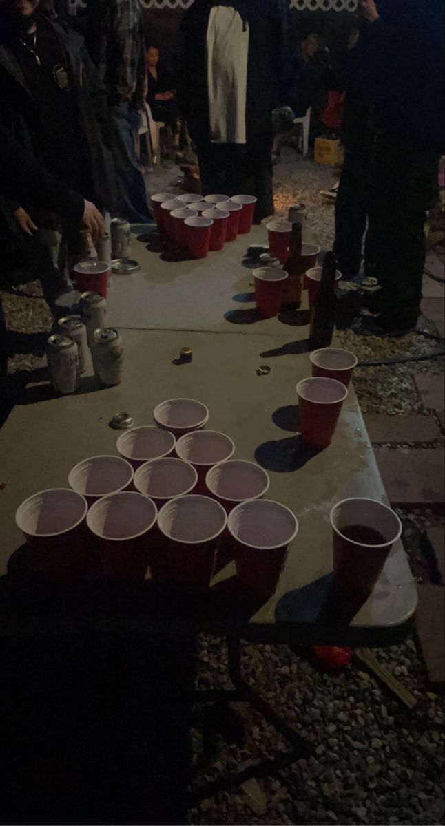 several people standing around a table with cups on it