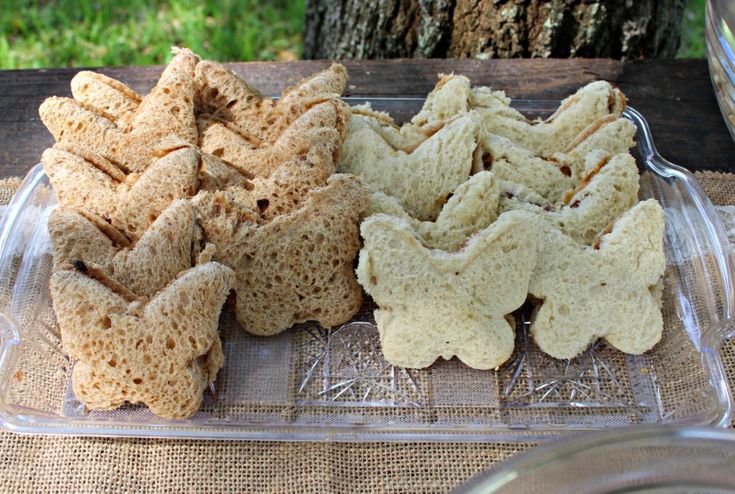 several pieces of bread sitting on top of a glass platter next to a tree