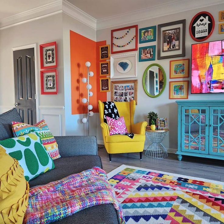 a living room filled with colorful furniture and pictures on the wall above it's fireplace