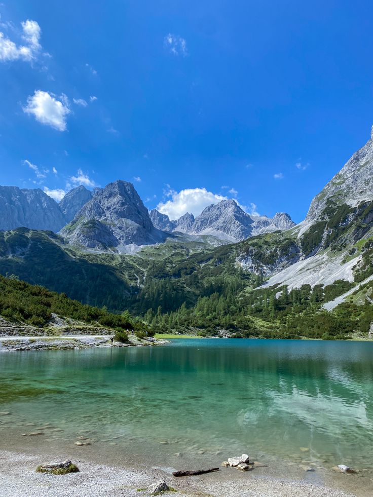 a mountain lake surrounded by mountains under a blue sky