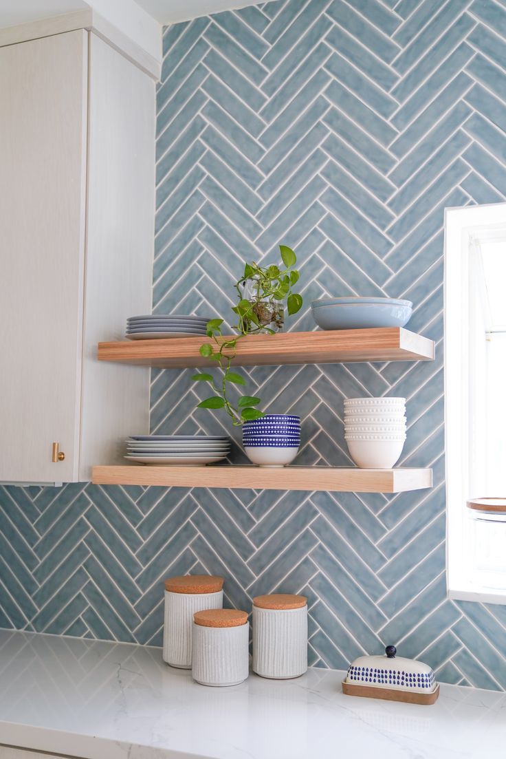 Miami Modern Kitchen with Bold Blue Herringbone Backsplash designed by KJ Design Collective. This kitchen was transformed by adding a bold backsplash, ample seating, dramatic wallpaper and floor to ceiling storage solutions. Blue Herringbone Backsplash, Blue Tile Backsplash Kitchen, Blue Herringbone Tile, Blue Backsplash Kitchen, Blue Kitchen Tiles, Coastal Kitchen Decor, Wallpaper Kitchen, Decor Ideas Kitchen, Blue Backsplash