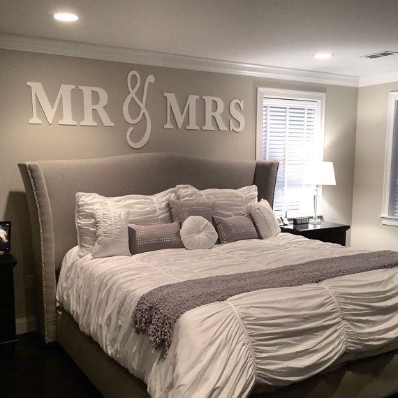 a large bed sitting in a bedroom under a mr and mrs decal on the wall