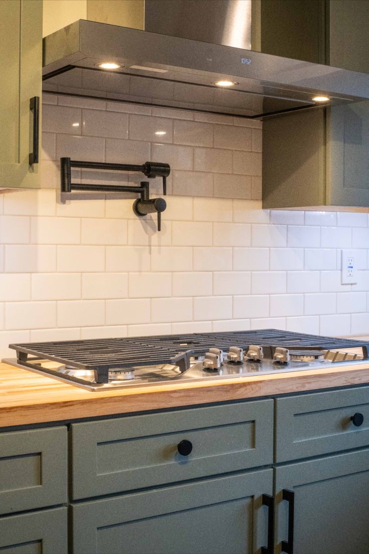 a stove top oven sitting inside of a kitchen next to cupboards and counter tops