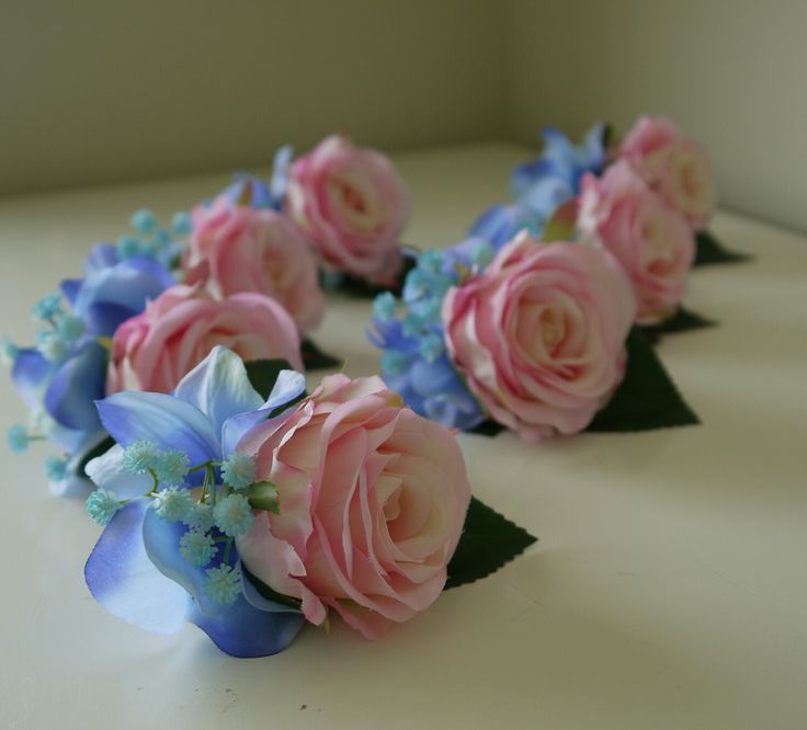 some pink and blue flowers on a white table