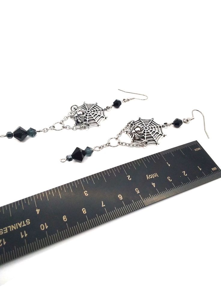 Made to Order! This earring set features a spider on its web. Perhaps it is reeling in its tangled prey? They can be worn with Gothic, fantasy inspired, steampunk or any other outfits you wish. This elegant design is the perfect pair with one of my necklaces or rosary chains! They also go really well with layers of stacked silver statement necklaces. These earrings make a perfect gift for someone who loves spiders and insects or ornate silver toned jewelry. Each earring weighs approx. .2 oz. ﻿Th Themed Black Metal Jewelry, Black Earrings For Halloween Cosplay, Black Halloween Cosplay Earrings, Fantasy Metal Earrings With Ear Wire, Fantasy Dangle Earrings For Halloween, Halloween Fantasy Dangle Earrings, Steampunk Silver Jewelry For Cosplay, Fantasy Halloween Dangle Earrings, Gothic Metal Earrings For Halloween