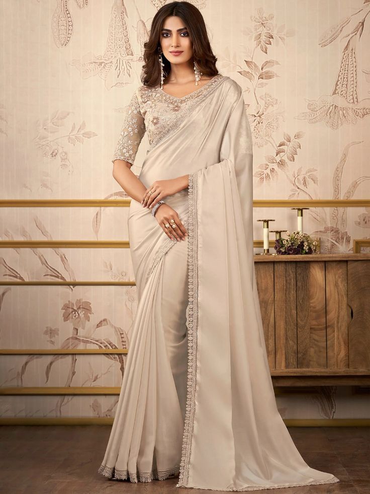 Gauri Satin Embroidered Stone Work Designer Border Saree Premium quality fabric Enhanced with thread & tiki embroidery work. Comes with unstitch blouse fabric Turn up the glamour with the Gauri Saree! Made with luxurious satin and embellished with stunning embroidered stone work, this designer border saree is sure to make a statement. Saree With Heavy Blouse, Off White Saree, Heavy Blouse, Simple Saree Designs, Organza Silk Saree, Plain Saree, Simple Sarees, White Saree, Satin Saree