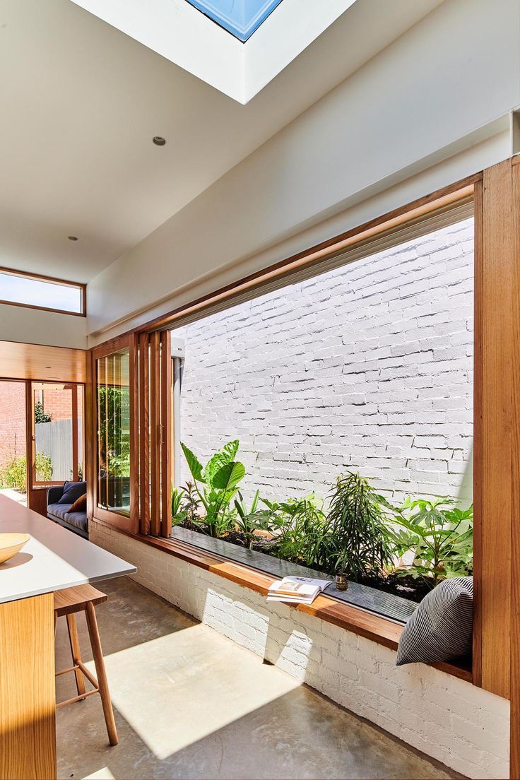 an open kitchen and living room with plants in the window sill on either side