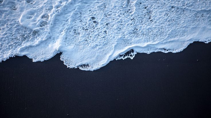 an aerial view of the ocean with waves