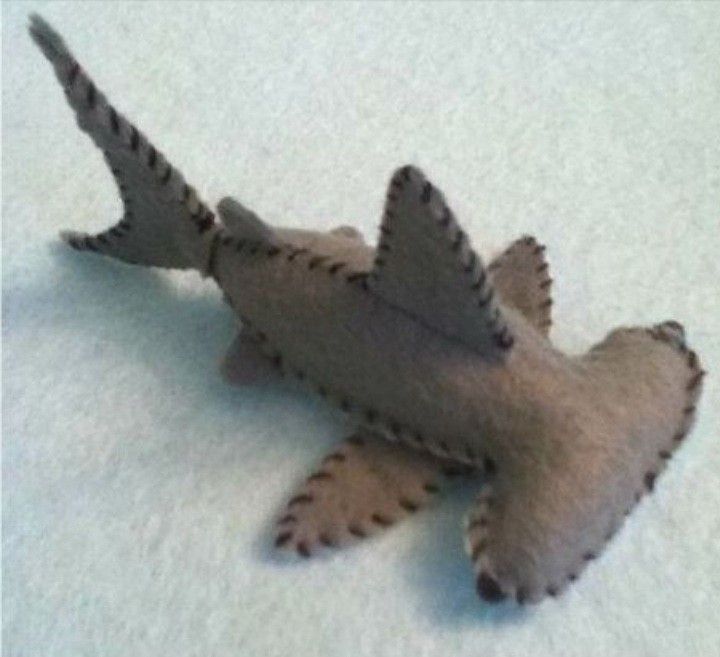 a toy shark laying on top of snow covered ground