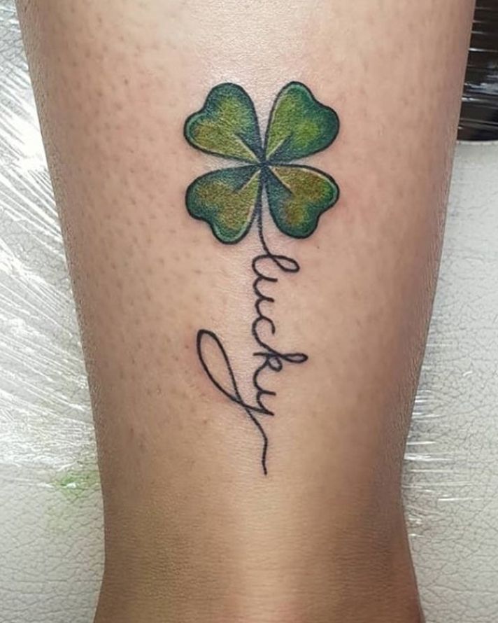 a woman's leg with a four leaf clover tattoo on it