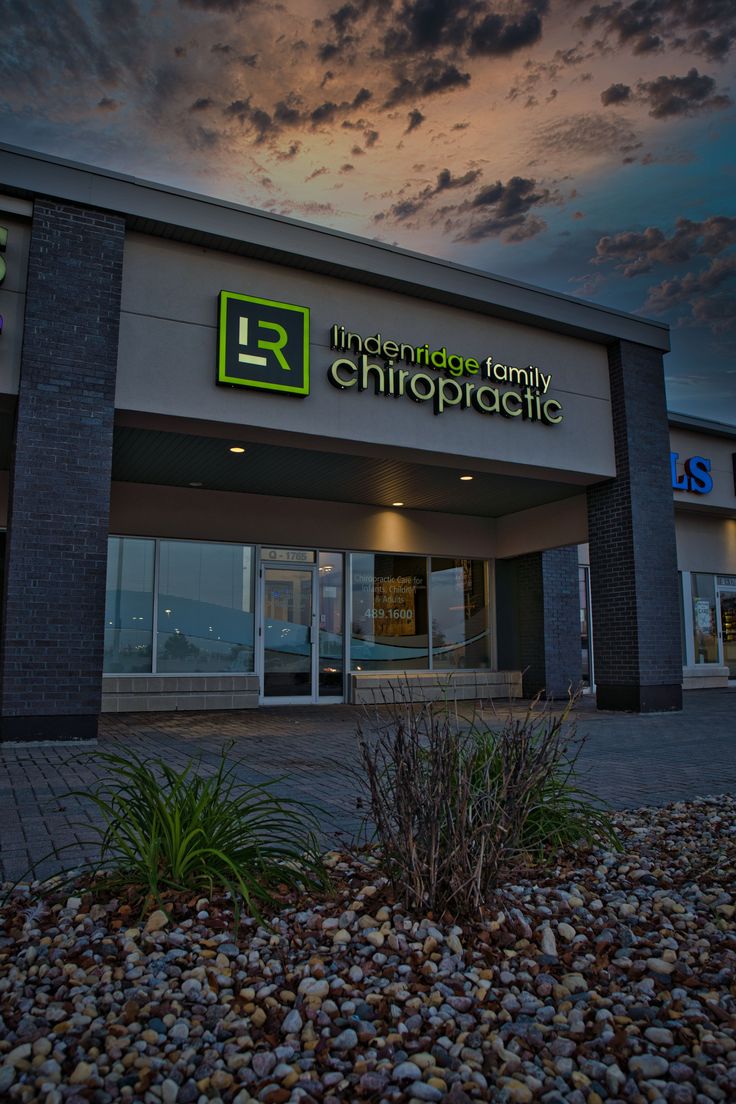 the front of a building with a sky in the background and clouds above it at dusk