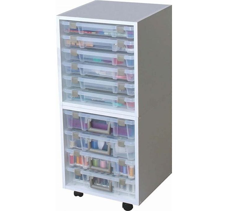 a white storage cabinet with lots of drawers on it's sides and plastic bins in the bottom drawer