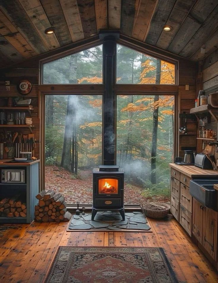 a wood burning stove sitting inside of a living room next to a large glass window