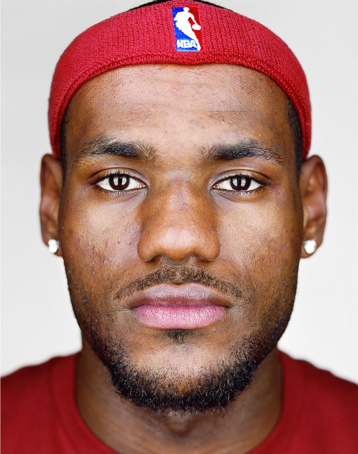 a close up of a person wearing a red hat with a basketball logo on it